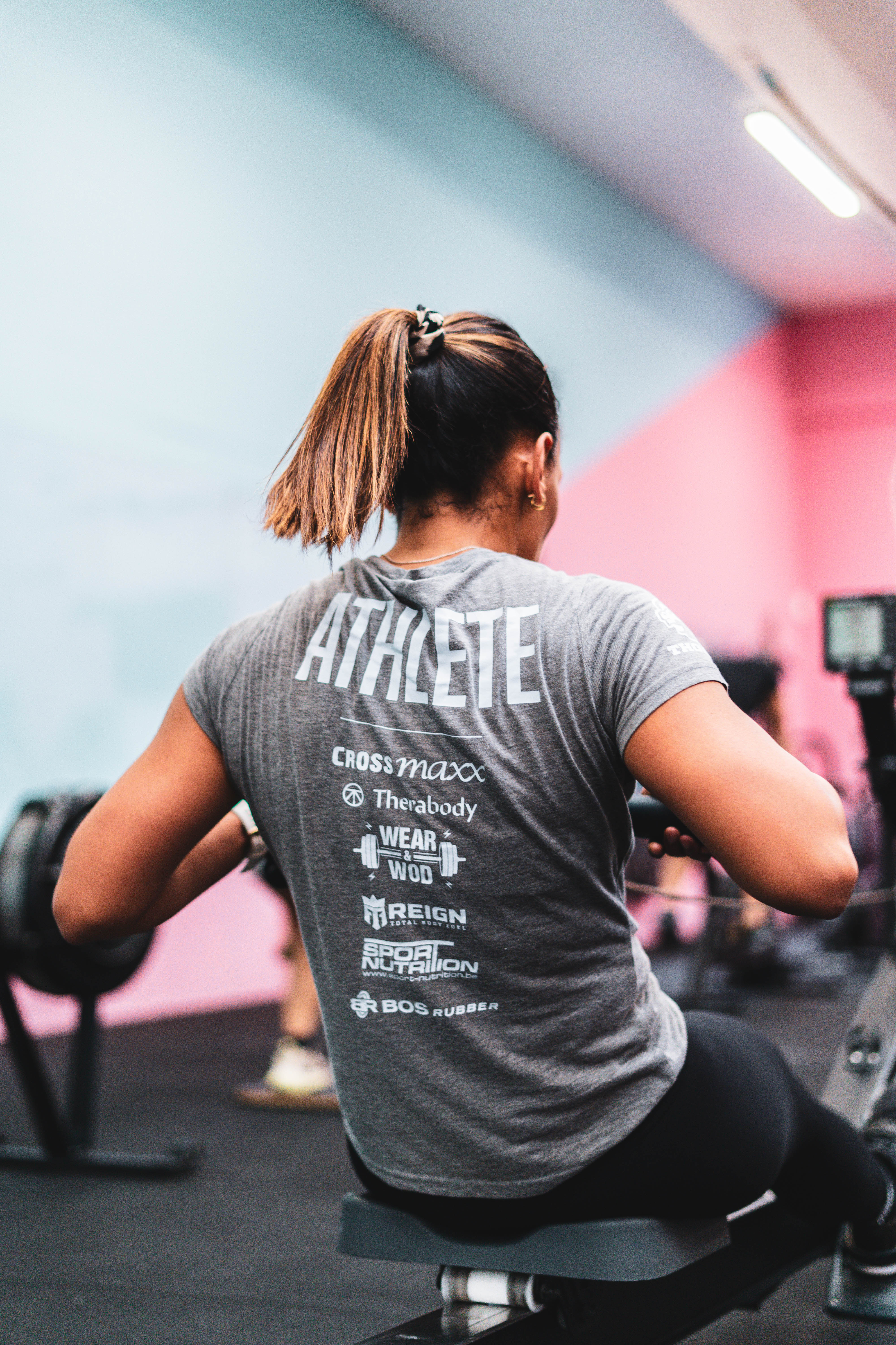 Athlète de dos portant un t-shirt 'Athlete' sur un rameur